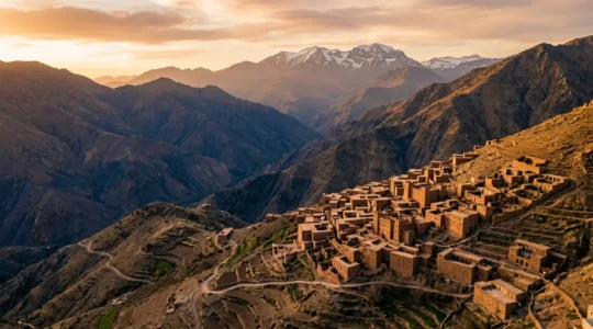 Vue panoramique d'un village berbère traditionnel du Haut Atlas marocain au coucher du soleil avec architecture en pisé