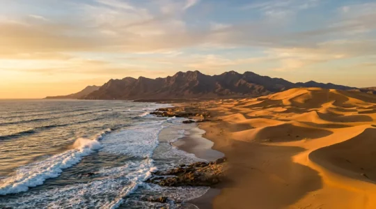 Vue panoramique combinant plage atlantique d'Essaouira et dunes sahariennes en arrière-plan