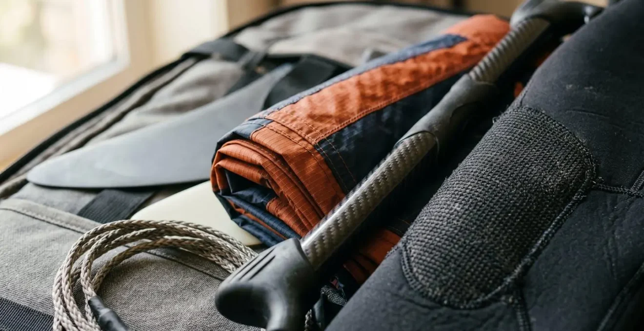 Matériel de kitesurf soigneusement rangé dans un sac de voyage ouvert